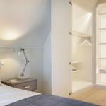 Bedroom with bed, nightstand, and wardrobe with shelves.
