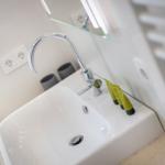 Modern sink with chrome faucet and mirror cabinet.