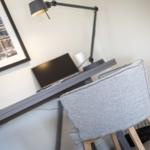 Desk with chair, lamp, and picture on the wall.