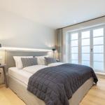 Bedroom with double bed, window, and bedside table.