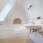 Badezimmer mit Dusche, Waschbecken und Fenster