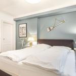 Bedroom with double bed, nightstands, and wall decor.