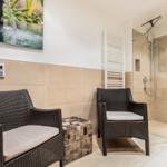 Bath with shower, two chairs, and wall picture