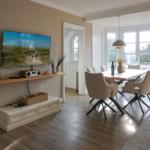 Living and dining area with TV, dining table, and windows.