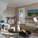Living room with armchair, table, and TV mounted on the wall.