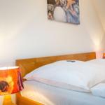 Schlafzimmer mit Bett, Nachttisch und Wandbild