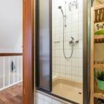 Dusche mit Glaswand, Holzregal und Pflanzen