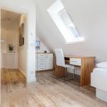 Bedroom with skylight, desk, and bed.