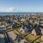 Aerial view of a coastal village with houses near the sea.