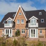 Two-story house with balcony, terrace, and garden. Roof with skylights.