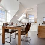Dining room with wooden table, chairs, and windows to terrace.