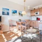Living kitchen with wooden furniture, dining area, and TV.