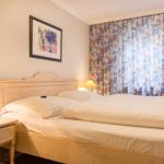 Bedroom with double bed, nightstand, and floral curtains.