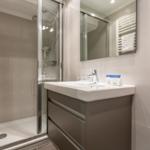 Bathroom with shower, sink, and towel rack