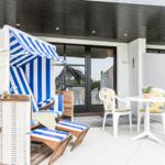Terrace with beach chair, table and chairs under roof