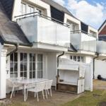 House with balconies, terrace, and white garden furniture set.