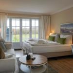 Bedroom with bed, sofa, TV, and window with view.