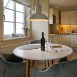 Round table with chairs, wine, and light above the table