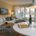Living and dining area with sofa, TV, and table. Doorway to the garden.