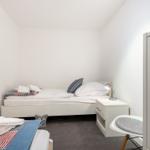 Ein Schlafzimmer mit Bett, Nachttisch, Stuhl und Kleiderschrank.