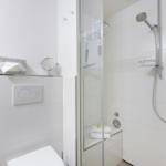 Badezimmer mit Dusche, Toilette und Heizung