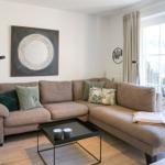 Wohnzimmer mit Ecksofa, Couchtisch und Fenster zur Terrasse.