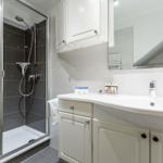 Badezimmer mit Dusche, Waschbecken und Spiegelschrank