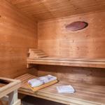 Sauna mit Holzbank, Thermometer und Handtuch