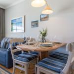 Esstisch mit Stühlen und Sofa im Wohnzimmer.