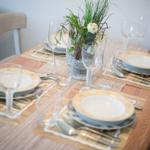 Tisch mit Platzsetzung, Gläsern und Blumendekoration.
