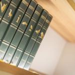 Reihe von Naturbüchern mit goldenen Tiermotiven auf Holzregal