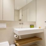 Moderne Badewanne mit Spiegel, Waschbecken und Holzbank