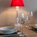 Table set with dishes, glasses, and a red lamp