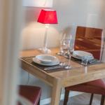 Dining table with two chairs, placemats, and a lamp.