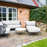 Terrace with seating group and table in front of brick house
