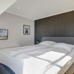 Bedroom with double bed, TV, and wooden wall
