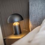 Bedroom with nightstand, lamp, and bed.