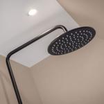 Shower head with black design mounted on ceiling.