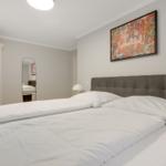 Bedroom with double bed, wardrobe, and wall art.
