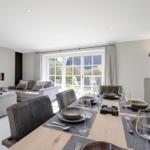 Dining area with table and chairs, living area with sofa and fireplace.