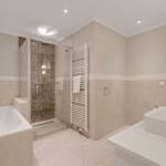 Bathroom with bathtub, shower, and sink.