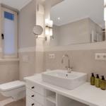 Bathroom with sink, mirror, and toilet.