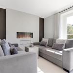 Living room with gray sofa, fireplace, and large window.