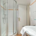 Bathroom with shower cabin, sink, and mirror.