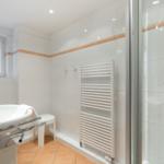 Bathroom with shower, sink, and heater