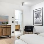 Schlafzimmer mit TV, Stuhl und Blick in Badezimmer