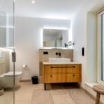 Badezimmer mit Dusche, Waschbecken und Fenster
