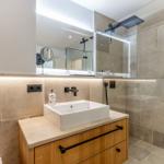 Bad mit Dusche, Waschbecken und Spiegel