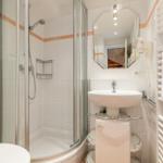 Bathroom with shower, sink, and towel warmer.