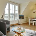 Living and dining area with window, sofa, table and chairs.